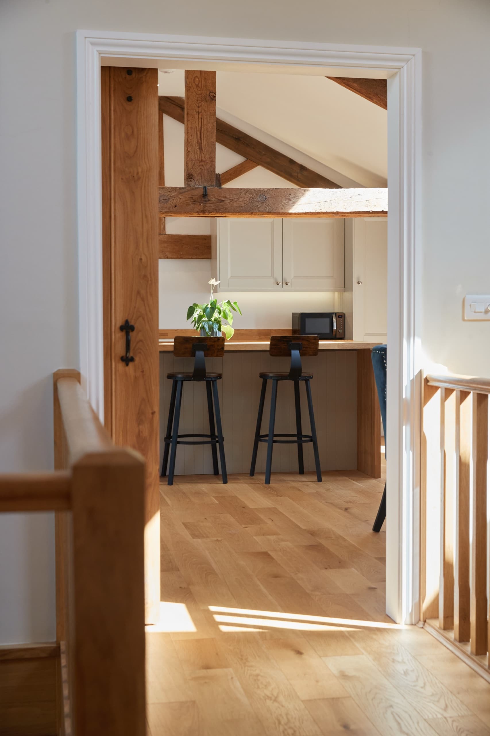 View through a sliding oak barn door to the open-plan kitchen
