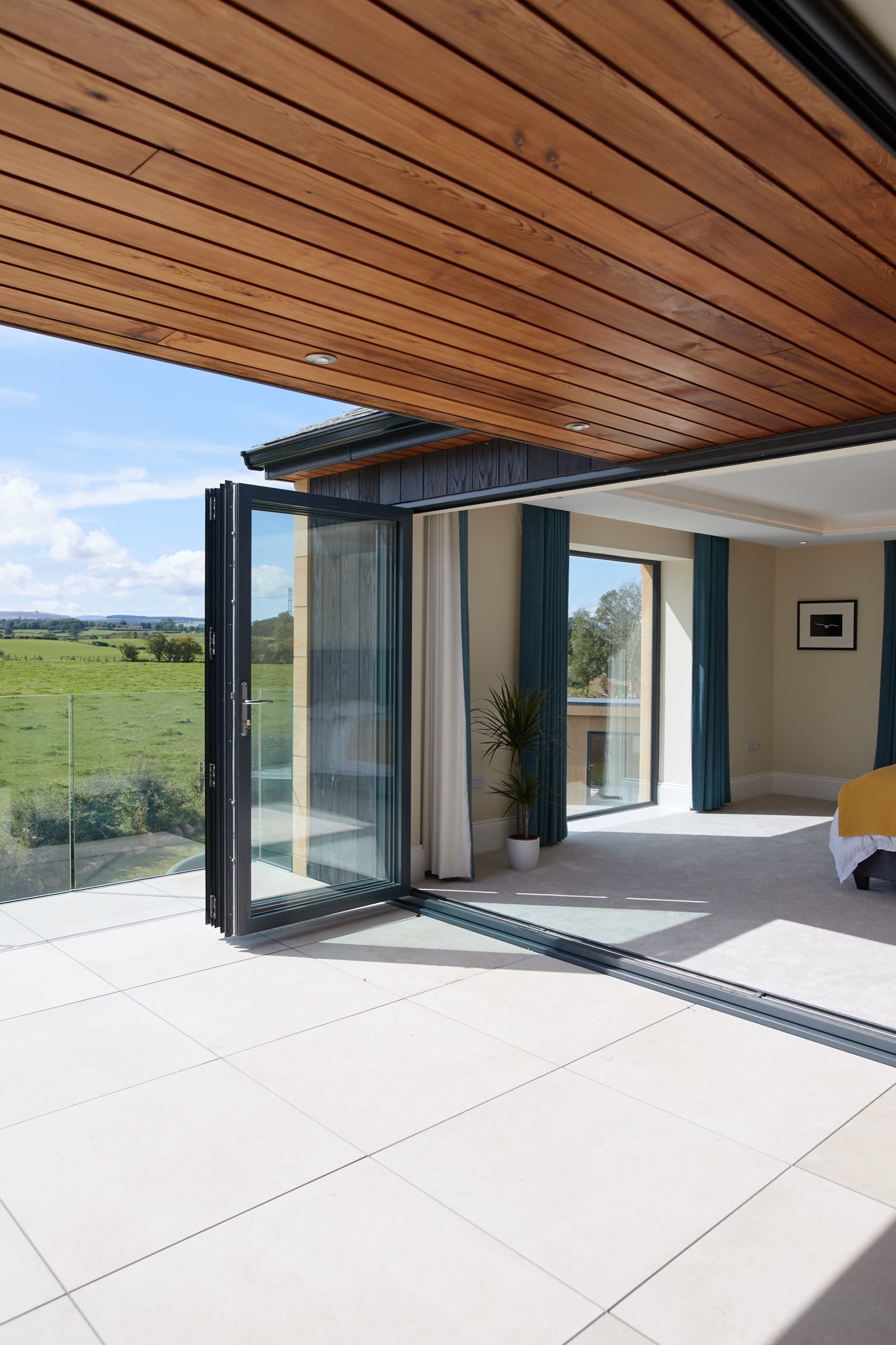 Principal bedroom opening through bifold doors onto a private terrace and the fells