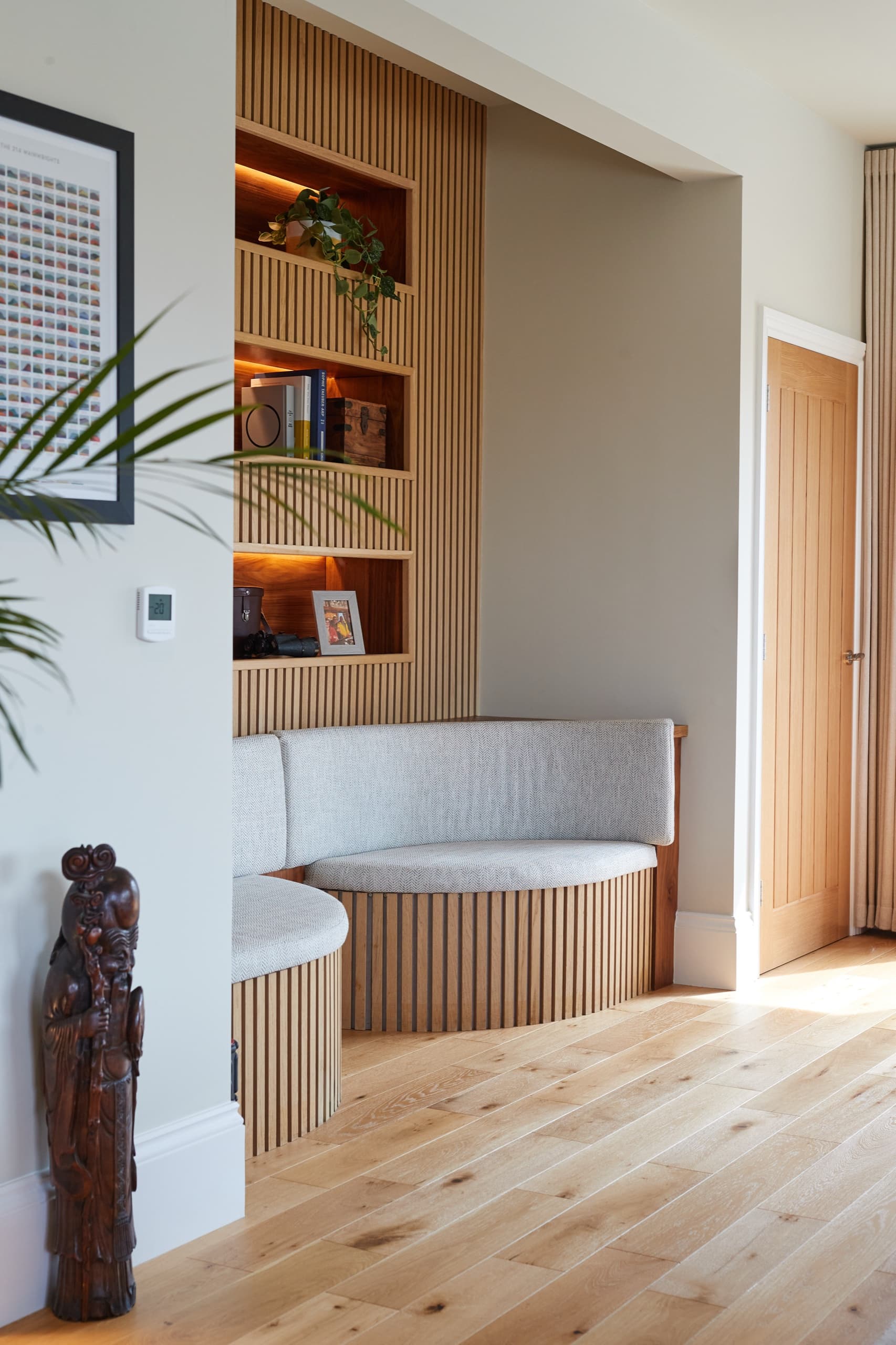 A curved oak-slatted banquette set into a panelled recess