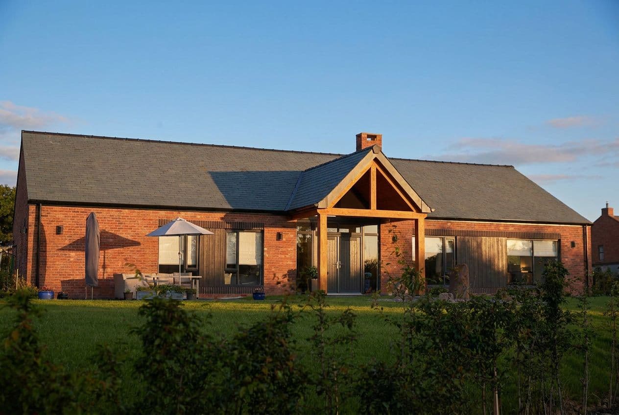 A single-storey Kiln Heights home with an oak-framed gable porch, in warm evening light