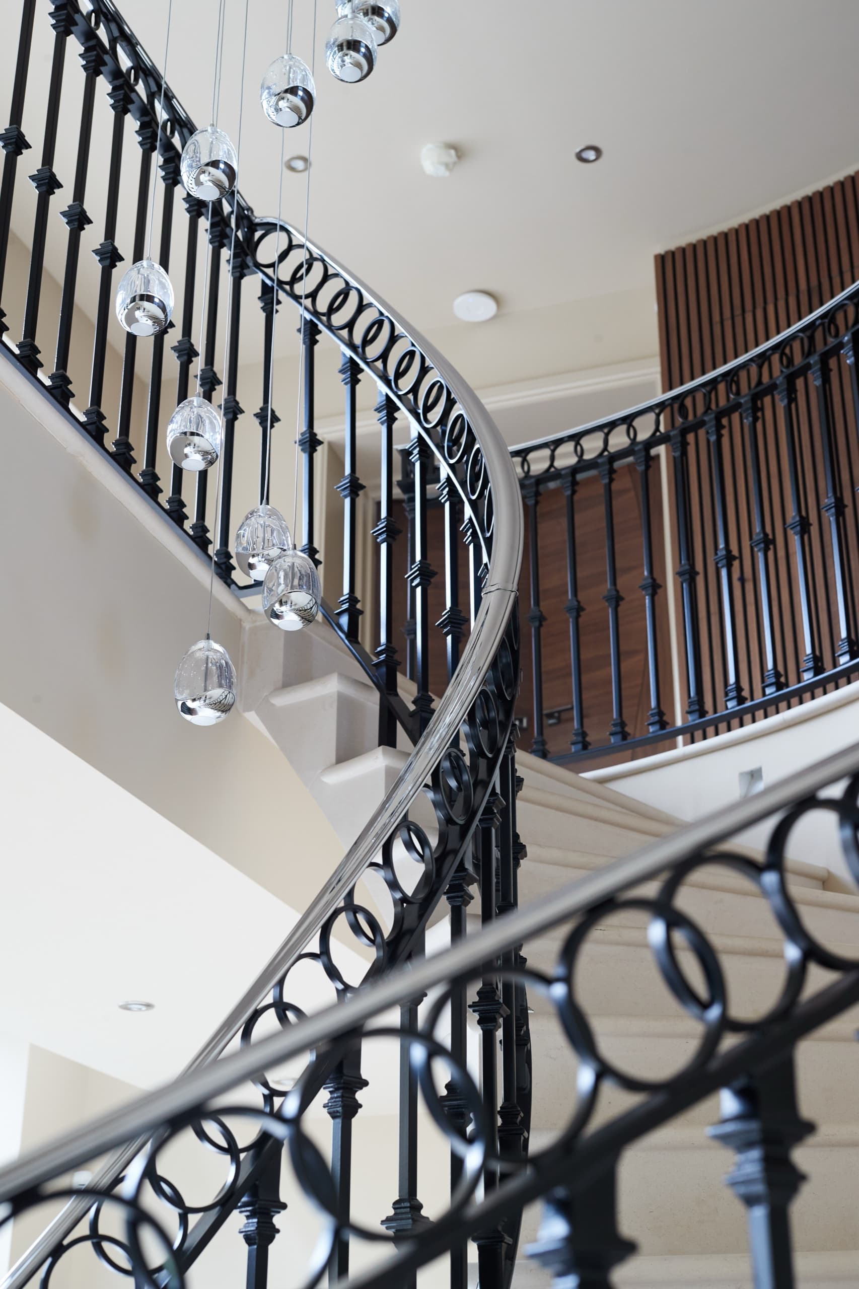 A sweeping wrought-iron staircase hung with crystal drop pendants
