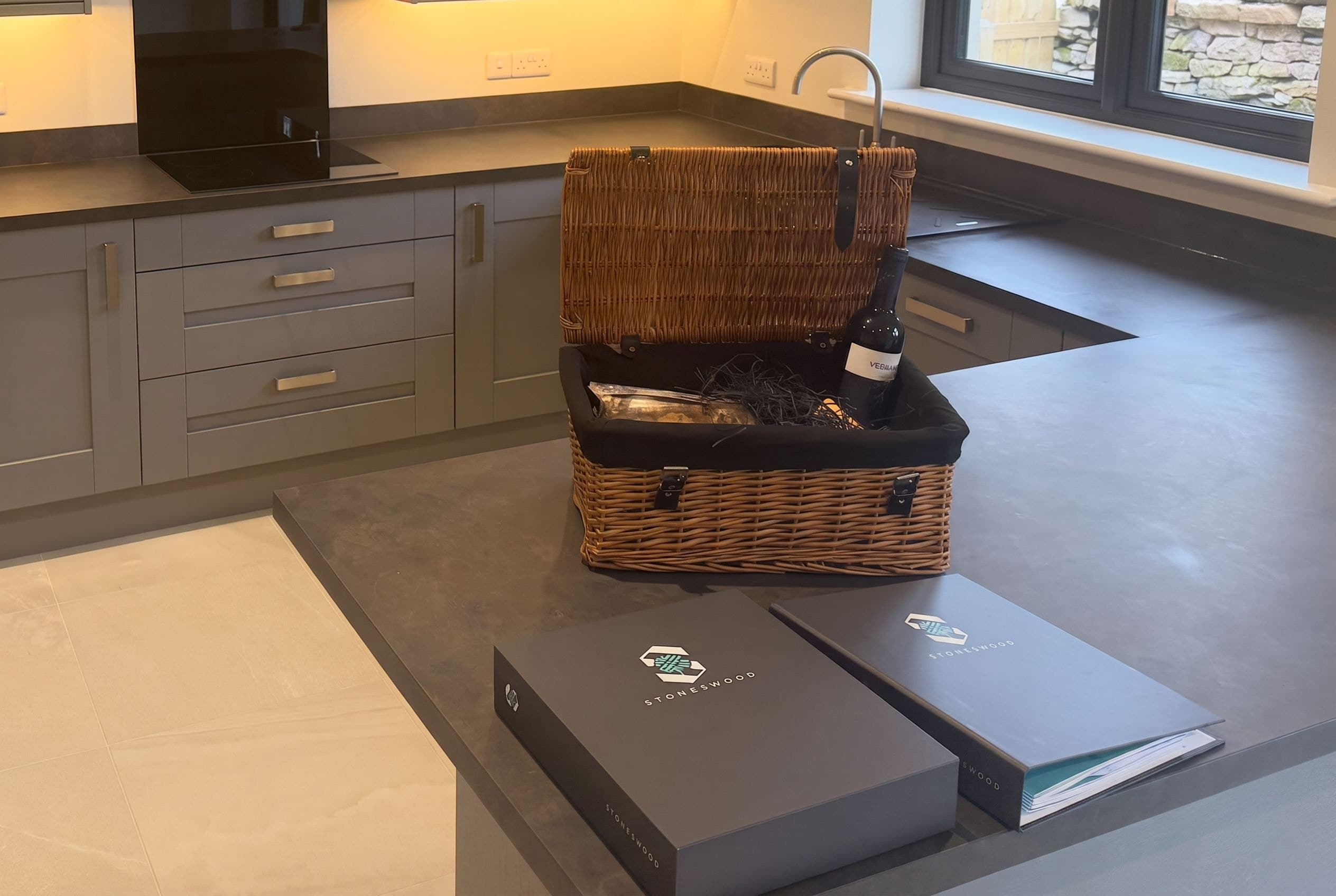 A welcome hamper and Stoneswood handover folders on the kitchen island of a newly completed home